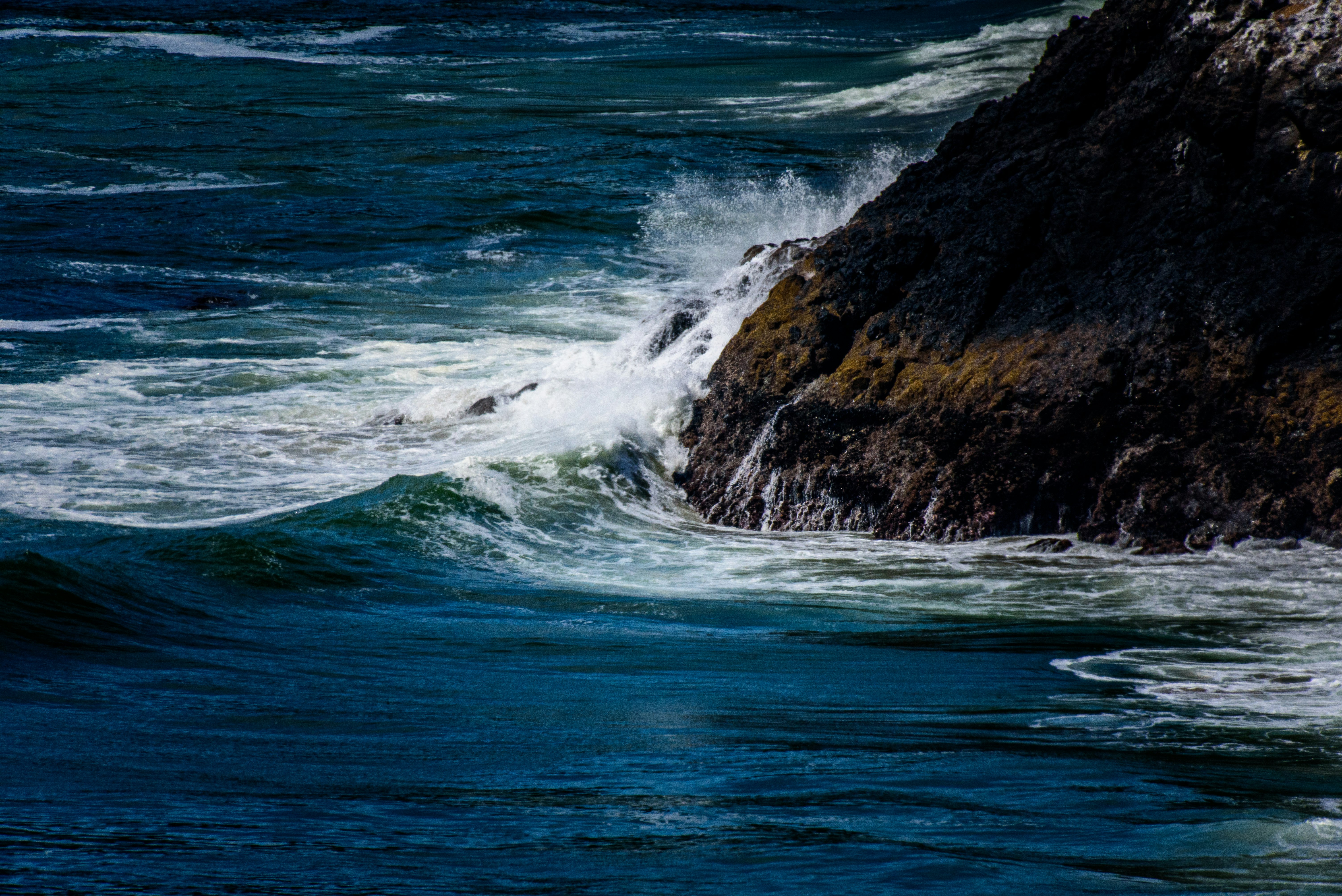 water wave hitting rock formation